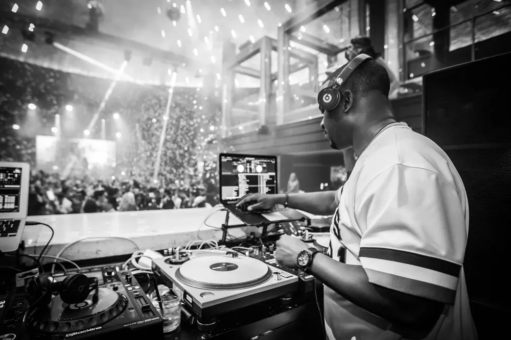 DJ M.O.S. on the main stage in black and white, confetti falling
